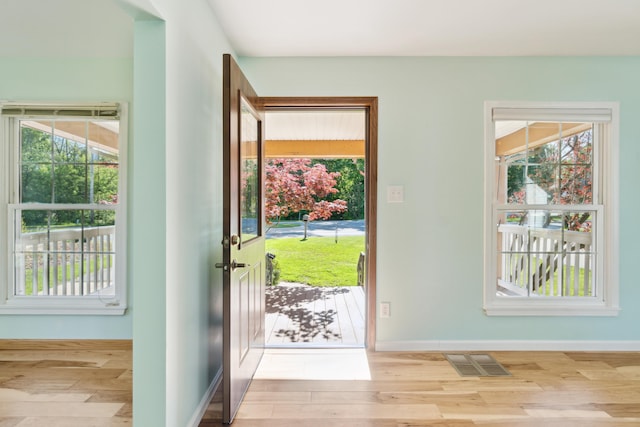 doorway with wood finished floors and baseboards