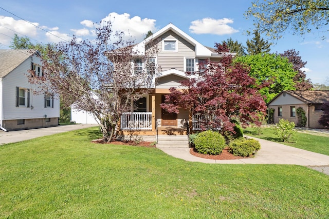 view of front of home with a porch, a front yard, and driveway
