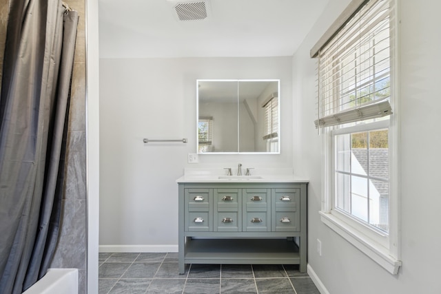 full bath featuring baseboards, vanity, and shower / tub combo with curtain