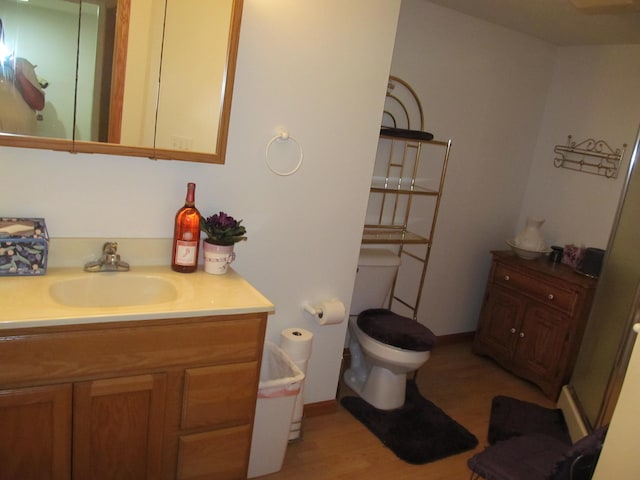 2625 Rolling Ridge Ln NW, Grand Rapids, MI 49534 - bathroom featuring vanity, wood finished floors, toilet, and baseboards