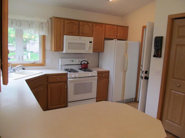 2625 Rolling Ridge Ln NW, Grand Rapids, MI 49534 - kitchen featuring white appliances, a sink, light countertops, a peninsula, and brown cabinetry