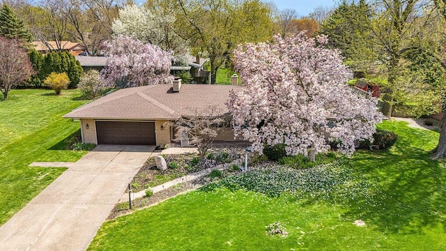 2655 Tanbark Trl, Saint Joseph, MI 49085 - view of front of house featuring an attached garage, a front lawn, driveway, a chimney, and brick siding