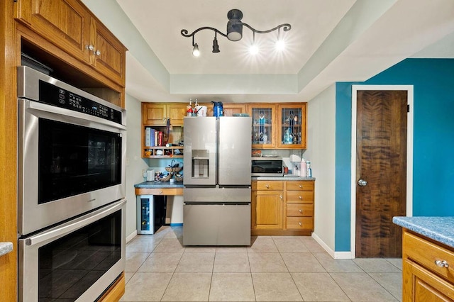 2655 Tanbark Trl, Saint Joseph, MI 49085 - kitchen with stainless steel appliances, a tray ceiling, and brown cabinetry