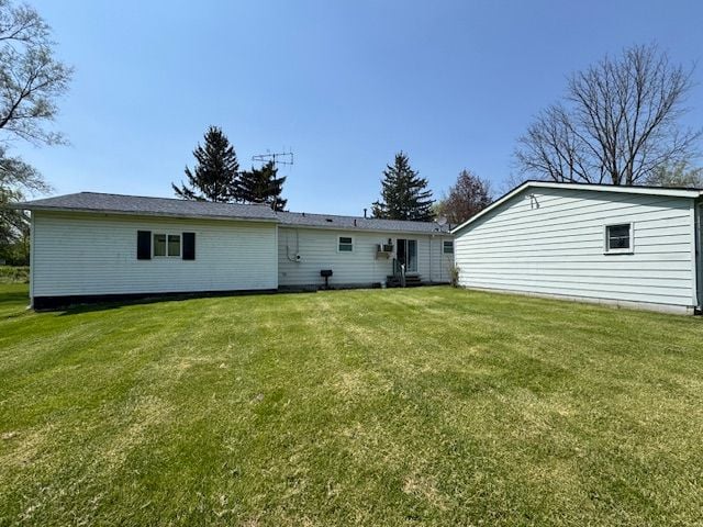 rear view of property featuring a yard