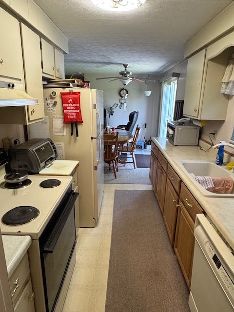 kitchen featuring range with electric cooktop, white dishwasher, a sink, light countertops, and a textured ceiling
