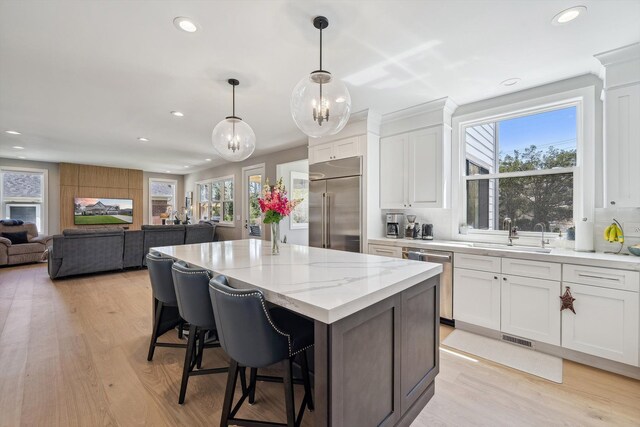 1663 Fairway Dr, Birmingham, MI 48009 - kitchen with stainless steel appliances, a sink, recessed lighting, white cabinets, and a kitchen breakfast bar