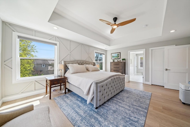1663 Fairway Dr, Birmingham, MI 48009 - bedroom with a tray ceiling, light wood-type flooring, a decorative wall, recessed lighting, and ensuite bath