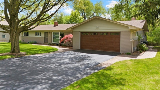 1831 Ansal Dr, Rochester Hills, MI 48309 - ranch-style house with a chimney, asphalt driveway, an attached garage, brick siding, and a front yard
