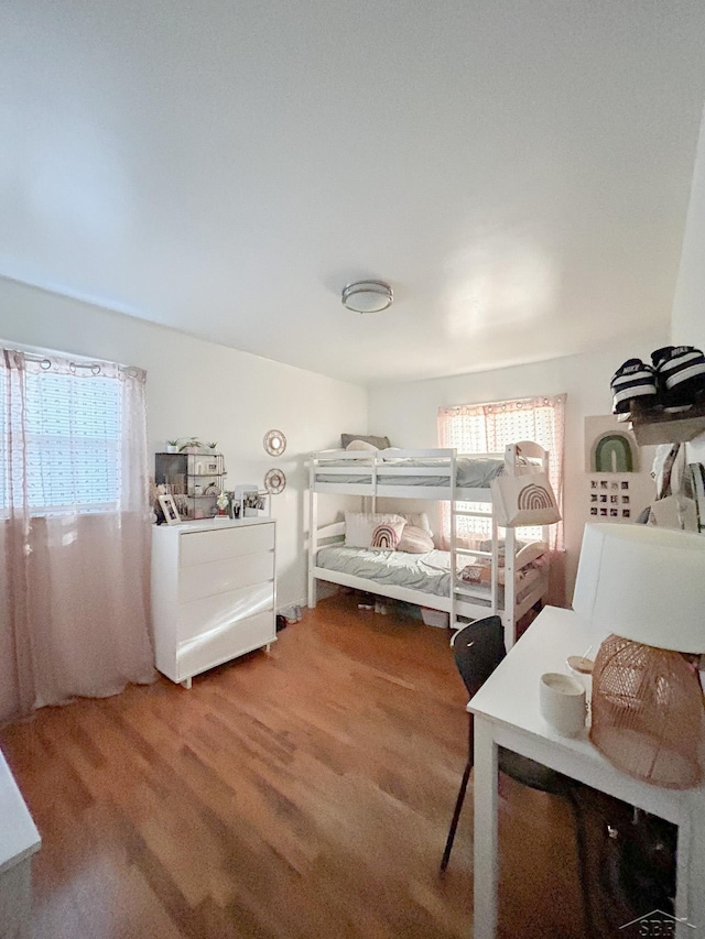 bedroom featuring wood finished floors and multiple windows
