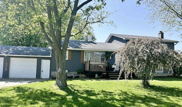 view of front of house featuring a chimney, a garage, and a front yard
