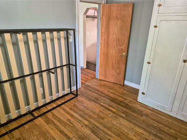 3188 Bessie St, Auburn Hills, MI 48326 - unfurnished bedroom with wood finished floors, baseboards, and arched walkways
