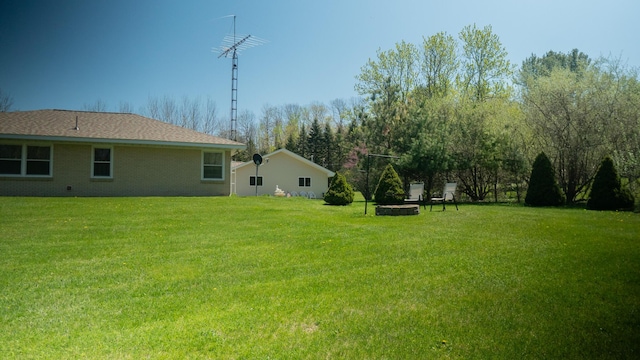 7198 Farr Rd, Onekama, MI 49675 - view of green lawn with an outdoor fire pit