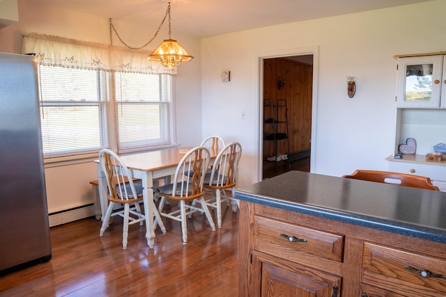 7198 Farr Rd, Onekama, MI 49675 - dining space featuring a chandelier, a baseboard heating unit, and wood finished floors