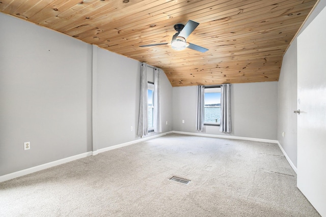 empty room with lofted ceiling, light carpet, wooden ceiling, a ceiling fan, and baseboards