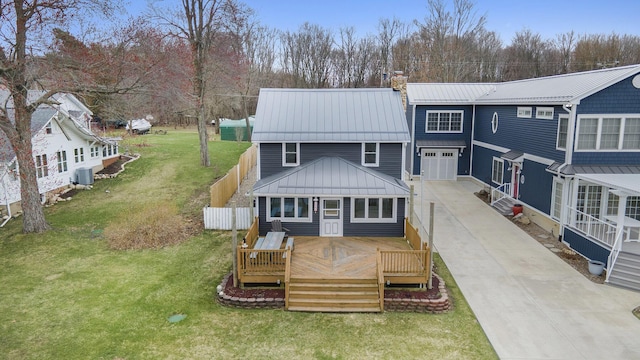 back of property with driveway, a chimney, metal roof, a deck, and central AC unit