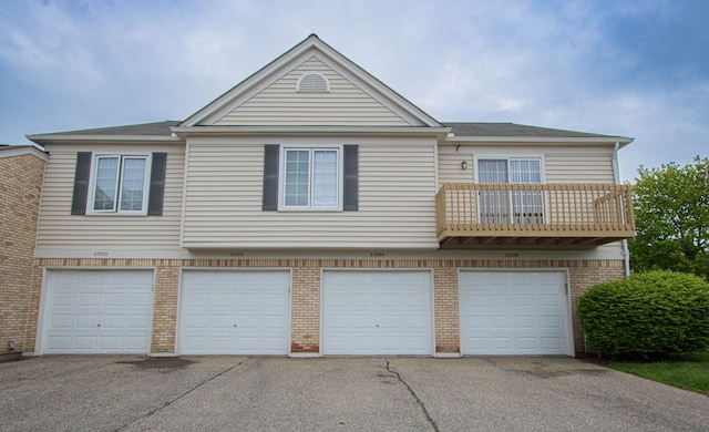 37374 Stonegate Cir, Clinton Township, MI 48036 - view of front of house featuring an attached garage, driveway, a balcony, and brick siding