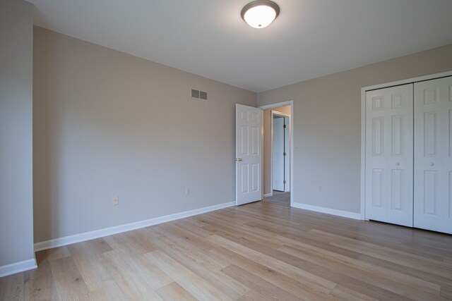 37374 Stonegate Cir, Clinton Township, MI 48036 - unfurnished bedroom with light wood-type flooring, baseboards, and a closet