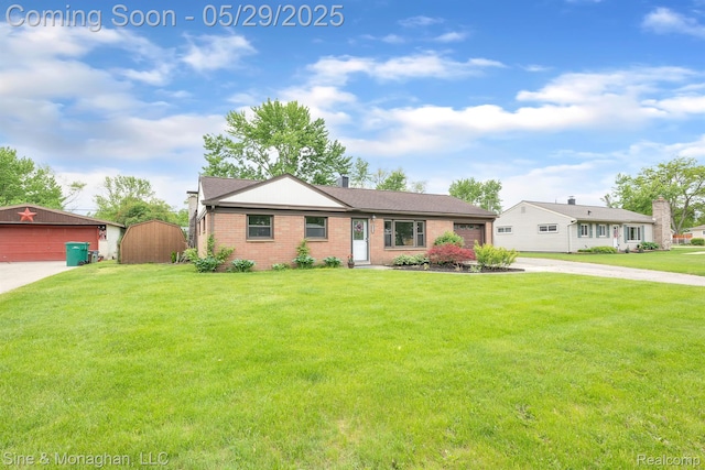 2514 Hearthside Dr, Ypsilanti, MI 48198 - ranch-style home featuring concrete driveway, brick siding, a front yard, a garage, and an outbuilding