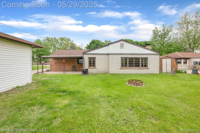 2514 Hearthside Dr, Ypsilanti, MI 48198 - rear view of house featuring brick siding, a patio area, a fire pit, a lawn, and central AC