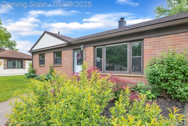 2514 Hearthside Dr, Ypsilanti, MI 48198 - view of front of property featuring brick siding, a chimney, and a front yard