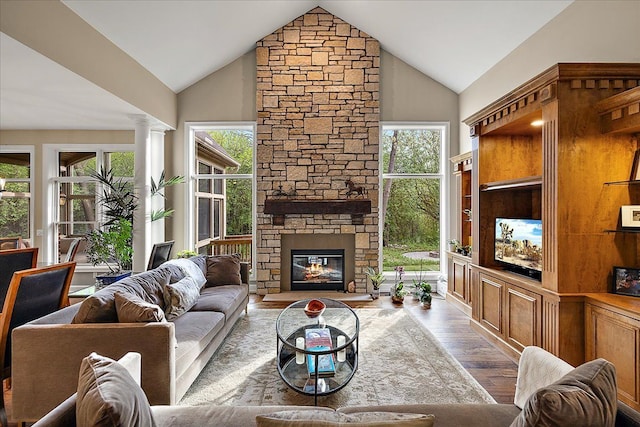4735 Oakhurst Ridge Rd, Clarkston, MI 48348 - living area with wood finished floors, high vaulted ceiling, a stone fireplace, and decorative columns