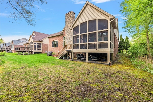 4735 Oakhurst Ridge Rd, Clarkston, MI 48348 - rear view of property with a sunroom, a chimney, a yard, stairs, and brick siding