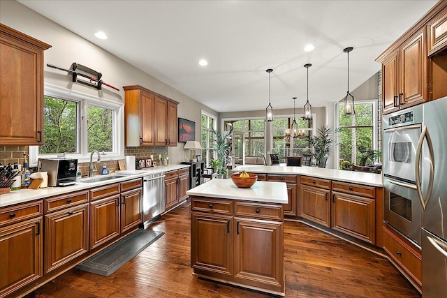 4735 Oakhurst Ridge Rd, Clarkston, MI 48348 - kitchen with appliances with stainless steel finishes, a sink, light countertops, brown cabinetry, and healthy amount of natural light