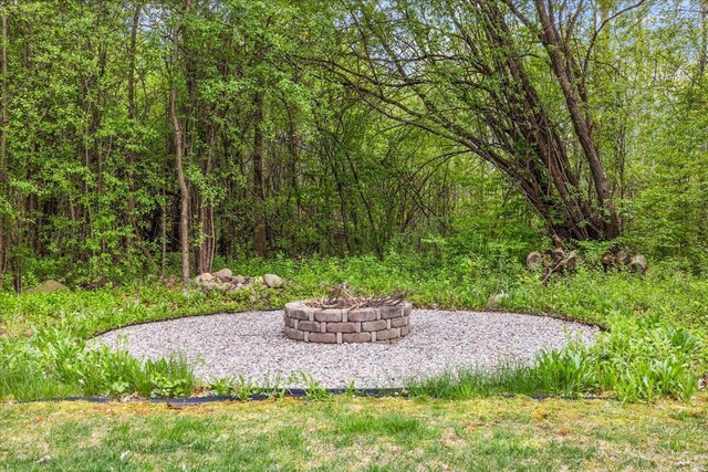 4735 Oakhurst Ridge Rd, Clarkston, MI 48348 - view of yard with an outdoor fire pit and a wooded view