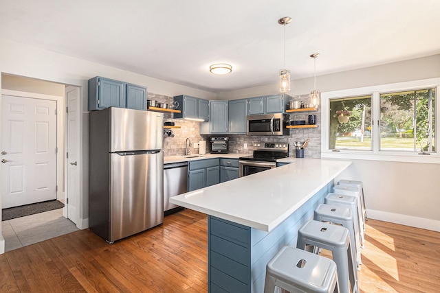 926 Brighton Lake Rd, Brighton, MI 48116 - kitchen featuring open shelves, stainless steel appliances, a peninsula, a sink, and light countertops