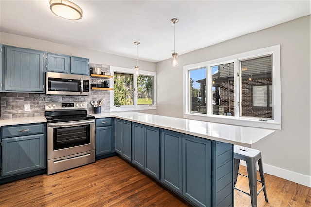 926 Brighton Lake Rd, Brighton, MI 48116 - kitchen featuring stainless steel appliances, tasteful backsplash, decorative light fixtures, dark wood-style floors, and light countertops