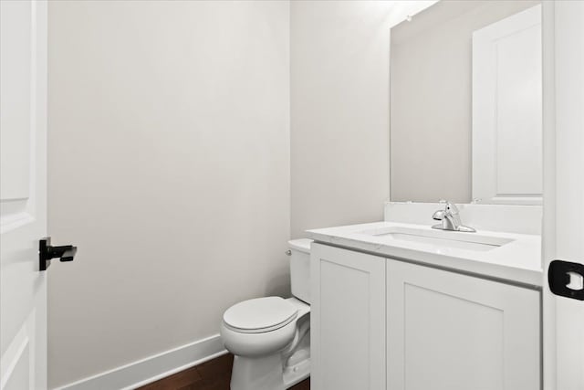 2080 Crested Butte Dr, White Lake, MI 48383 - half bathroom featuring toilet, vanity, wood finished floors, and baseboards