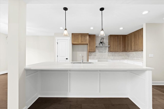2080 Crested Butte Dr, White Lake, MI 48383 - kitchen with a sink, wall chimney exhaust hood, backsplash, brown cabinetry, and recessed lighting