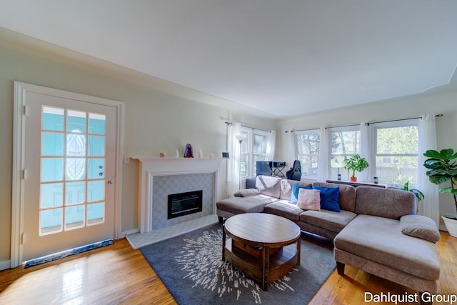 1573 N Whitehall Rd, Muskegon, MI 49445 - living room featuring wood finished floors, a tiled fireplace, and baseboards