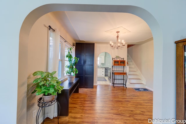 1573 N Whitehall Rd, Muskegon, MI 49445 - entrance foyer with arched walkways, wood finished floors, stairs, and a chandelier