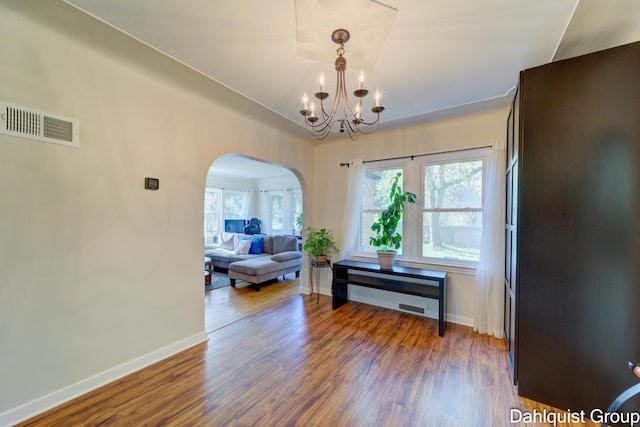 1573 N Whitehall Rd, Muskegon, MI 49445 - dining room with arched walkways, wood finished floors, a chandelier, and baseboards
