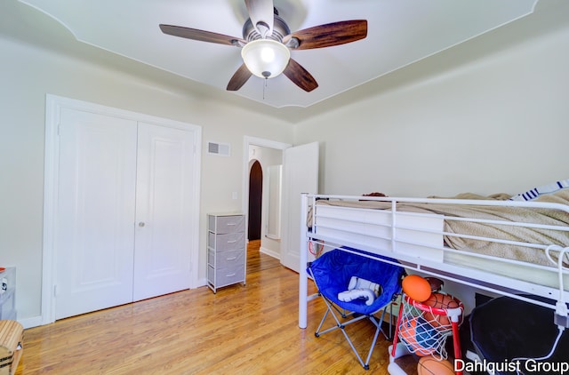 1573 N Whitehall Rd, Muskegon, MI 49445 - bedroom featuring arched walkways, wood finished floors, ceiling fan, and a closet