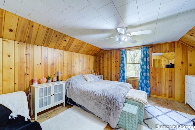 1573 N Whitehall Rd, Muskegon, MI 49445 - bedroom featuring vaulted ceiling, wooden walls, wood finished floors, and ceiling fan