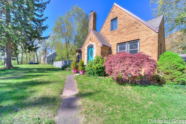 1573 N Whitehall Rd, Muskegon, MI 49445 - view of front of property with brick siding, a front lawn, a chimney, and a shingled roof