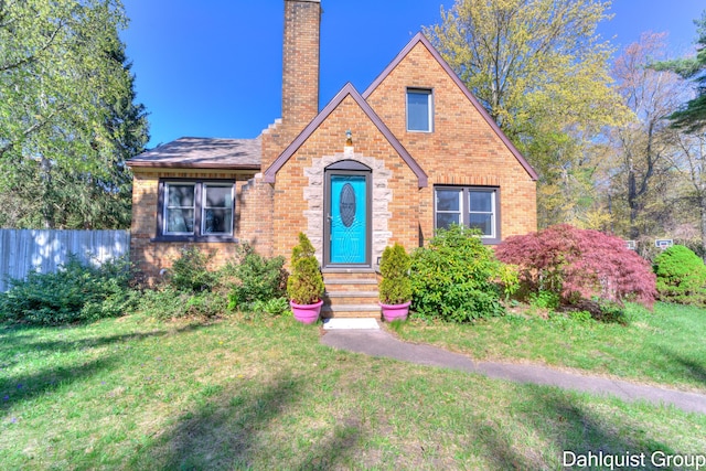 1573 N Whitehall Rd, Muskegon, MI 49445 - tudor home featuring a chimney, brick siding, and entry steps
