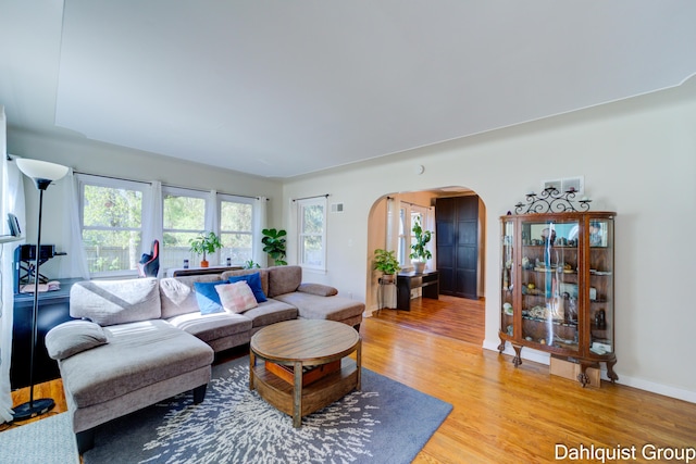 1573 N Whitehall Rd, Muskegon, MI 49445 - living room with arched walkways, light wood-type flooring, and baseboards