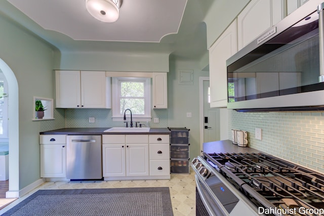 1573 N Whitehall Rd, Muskegon, MI 49445 - kitchen featuring a sink, stainless steel appliances, dark countertops, and white cabinetry
