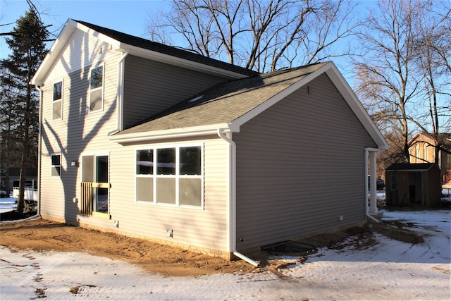 00 High Slope Dr, Brighton, MI 48114 - snow covered property with a shingled roof, a storage shed, and an outdoor structure