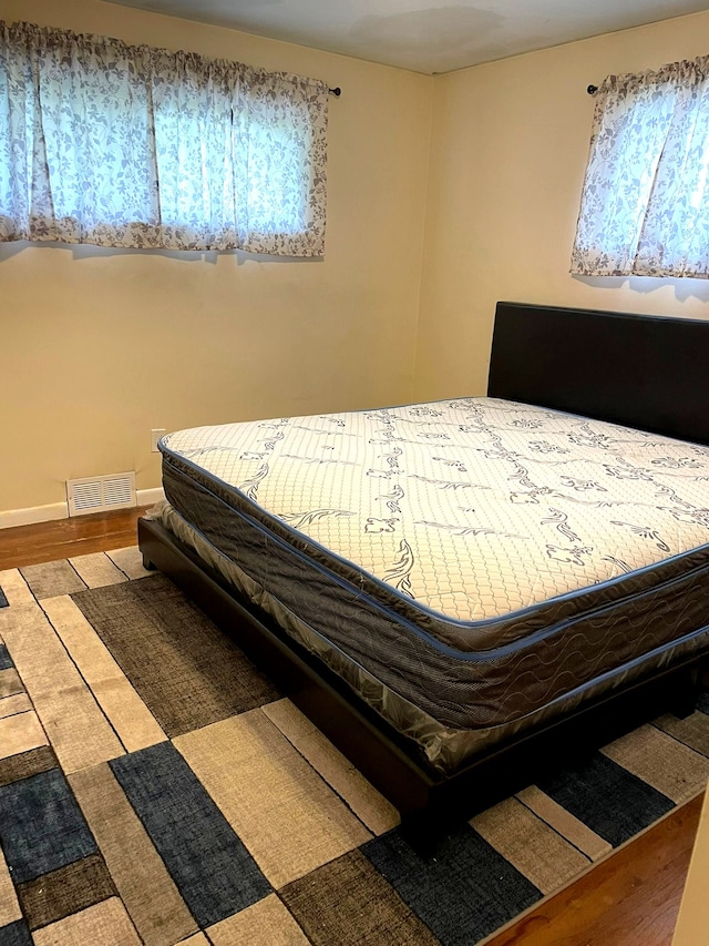 bedroom featuring wood finished floors and baseboards
