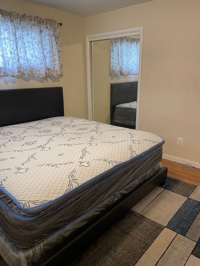 bedroom with wood finished floors and baseboards