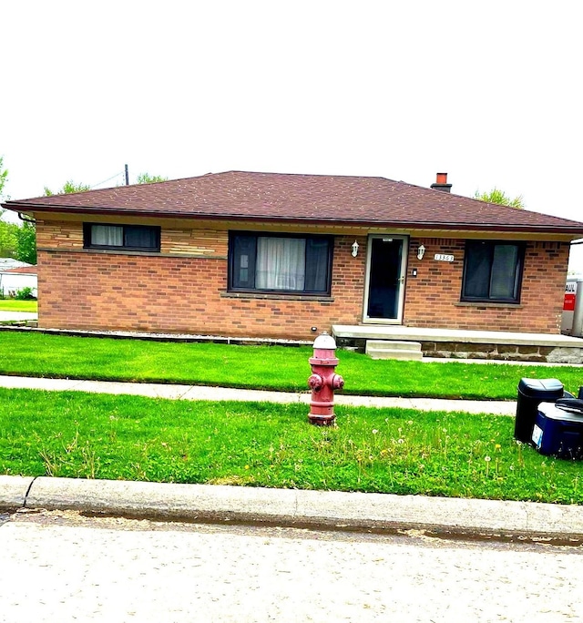 ranch-style house with brick siding and a front yard