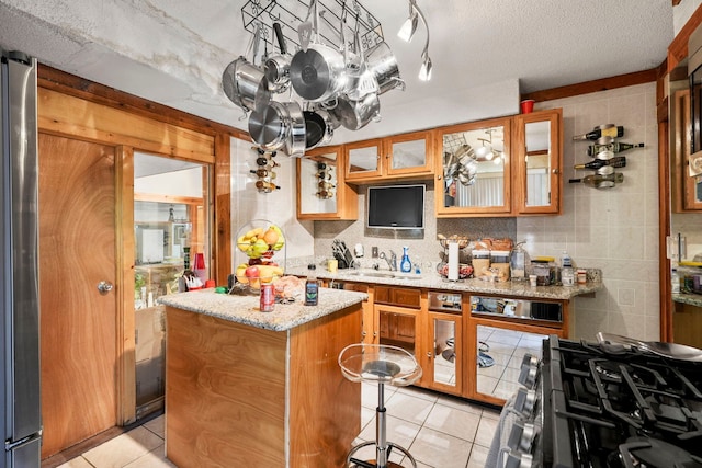 19303 Fenmore St, Detroit, MI 48235 - kitchen with light tile patterned floors, a center island, brown cabinets, a sink, and glass insert cabinets