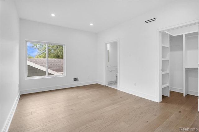 227 W Houstonia Ave, Royal Oak, MI 48073 - unfurnished bedroom with light wood-type flooring, recessed lighting, baseboards, connected bathroom, and a walk in closet