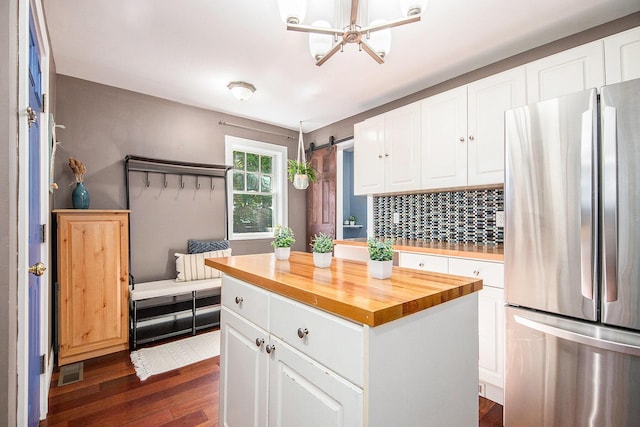 kitchen featuring freestanding refrigerator, dark wood-type flooring, wooden counters, and decorative backsplash