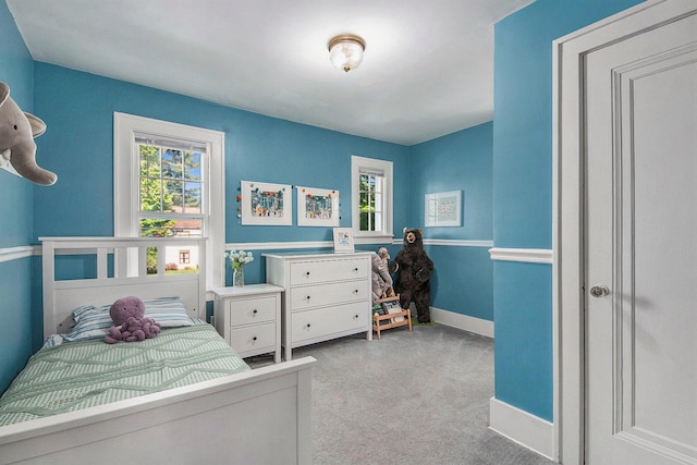 bedroom with multiple windows, carpet, and baseboards