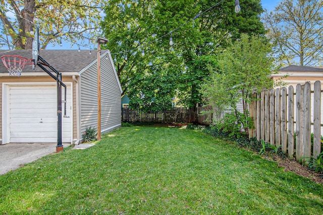 view of yard with a garage and asphalt driveway